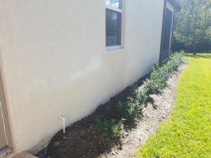 a white stucco house after rust removal pressure washing
